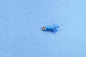 briljant blauw USB flash geheugen kaart met een blauw boog leugens Aan een deken van zacht en harig licht blauw fleece kleding stof. klassiek vrouw geschenk ontwerp voor een geheugen kaart foto