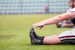 Amerikaans Amerikaans voetbal spelers uitrekken en opwarming omhoog foto