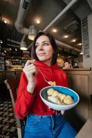 jong vrouw aan het eten ijs room Aan een koffie winkel foto