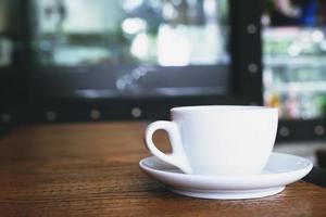 heet koffie kop in cafe Aan houten bamboe tafel. vertrekken kopiëren ruimte leeg naar schrijven de kant tekst. zacht focus. foto