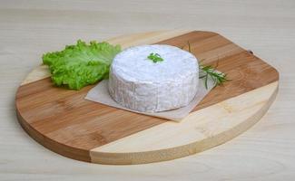 Camembert kaas Aan houten bord en houten achtergrond foto