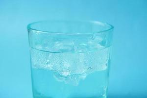 frisdrank in een glas met ijsblokje gieten foto