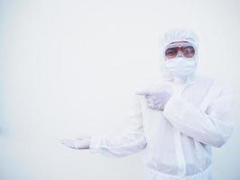 Aziatisch mannetje dokter of wetenschapper in ppe suite uniform tonen richten vingers weg Bij kopiëren ruimte terwijl staand en op zoek naar voren. coronavirus of covid-19 concept geïsoleerd wit achtergrond foto