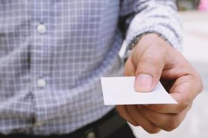 bedrijf Mens in hand- houden tonen blanco wit kaart bespotten omhoog met afgeronde hoeken. duidelijk belkaart bespotten omhoog sjabloon Holding arm. plastic credit naam kaart Scherm voorkant. bedrijf branding concept. foto