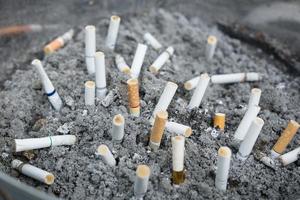 kont Aan sigaretten in de asbakje. Daar zijn veel types van sigaret stomp Aan de zand in de asbakje. een sigaret is niet mooi zo voor Gezondheid. foto