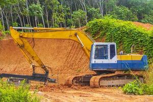 groot geel graafmachine opgravingen vernietigt Woud oerwoud Aan phuket Thailand. foto