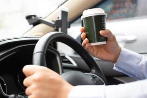 Mens is drinken heet koffie in de auto voordat gaan naar werk Bij de kantoor elke tijd. foto