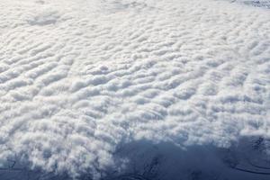 over- wolken top visie van vliegtuig venster, dik wit blauw wolken looks Leuk vinden zacht schuim foto