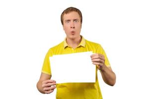 verrast jonge man met blanco vel papier, papieren mockup geïsoleerd op een witte achtergrond foto