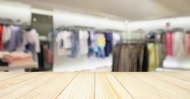 lege houten tafel met vrouw modieuze boutique kledingwinkel etalage in winkelcentrum foto