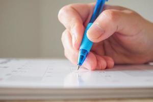 vrouw hand- met pen schrijven Aan kalender datum bedrijf planning afspraak vergadering concept foto