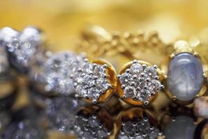 luxe goud sieraden diamant oorbellen en gouden saffier ring met reflectie Aan zwart achtergrond foto