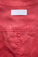 wit blanco kleding label etiket Aan rood linnen overhemd kleding stof structuur achtergrond foto