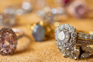 sieraden diamant ringen Aan gouden kleding stof achtergrond dichtbij omhoog foto