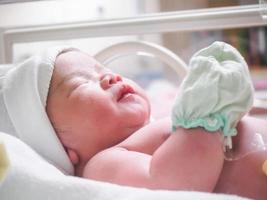 pasgeboren baby meisje binnen incubator in ziekenhuis post levering kamer foto