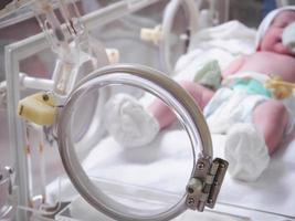 pasgeboren baby meisje binnen incubator in ziekenhuis post levering kamer foto