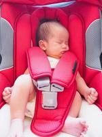 pasgeboren baby zitten in de auto stoel voor veiligheid foto