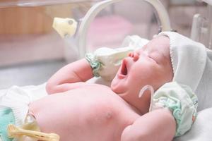 pasgeboren baby meisje binnen incubator in ziekenhuis post levering kamer foto