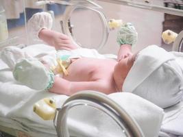 pasgeboren baby meisje binnen incubator in ziekenhuis post levering kamer foto