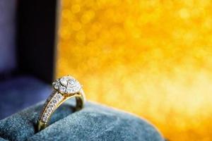 sieraden diamanten ring in geschenkdoos met abstracte feestelijke glitter kerst vakantie textuur achtergrond vervagen met bokeh licht foto