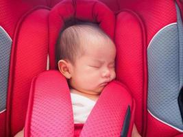 pasgeboren baby zitten in de auto stoel voor veiligheid foto