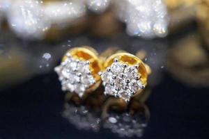 luxe gouden sieraden diamanten oorbellen met reflectie op zwarte achtergrond foto