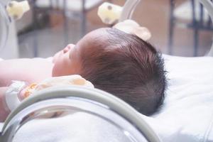 pasgeboren baby meisje binnen incubator in ziekenhuis post levering kamer foto