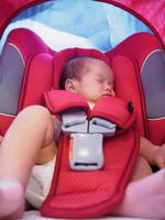 pasgeboren baby zitten in de auto stoel voor veiligheid foto