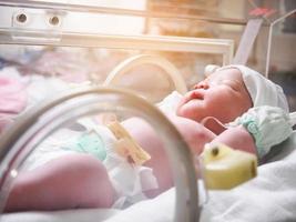 nieuw geboren baby zuigeling slaap in de incubator Bij ziekenhuis foto