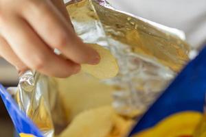 hand- houden aardappel chips met tussendoortje zak foto