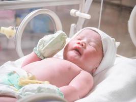 pasgeboren baby meisje binnen incubator in ziekenhuis post levering kamer foto
