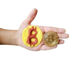 plasticine en echt bitcoin token in kinderen hand- geïsoleerd Aan wit achtergrond foto