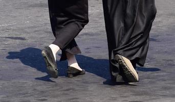 dichtbij omhoog van vrouw voeten wandelen. vrouw in lang rok en zwart schoenen wandelen foto
