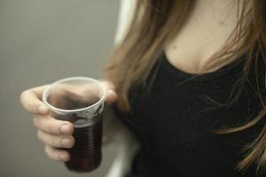 meisje houdt glas met drinken in haar hand. meisje drinken thee buiten. foto