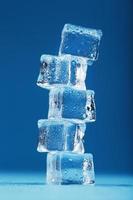 ijzig ijs kubussen in de het formulier van een toren Aan een blauw achtergrond. foto