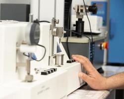 een detailopname schot van een hand- gebruik makend van een medisch machine naar test en vervaardiging farmaceutisch injectiespuiten foto