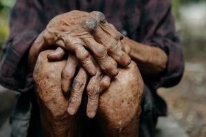 close-up van mannelijke gerimpelde handen, oude man draagt foto