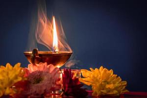 gelukkig divali. brandend diya olie lampen en bloemen Aan blauw achtergrond. traditioneel Indisch festival van licht. foto