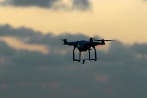 een quadrocopter met een foto camera vliegt over- de zee.