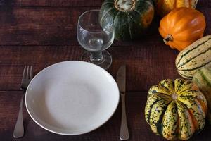 een single plaats instelling met een verscheidenheid van winter squash brengen kleur naar de tafel. foto