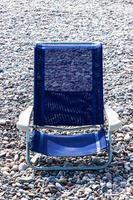 blauw strand stoel Aan keien. verticaal afbeelding. foto