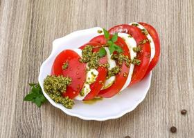 caprese salade in een kom Aan houten achtergrond foto