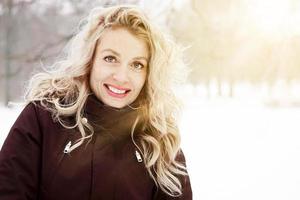 blond vrouw in winter landschap met zon gloed foto