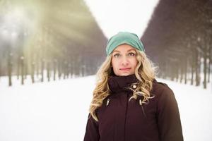 vrouw in sneeuw gedekt park Aan een zonnig winter dag foto