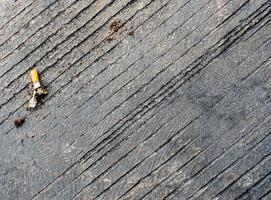 de sigarettenpeuk neergelaten op de betonnen vloer foto