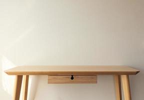 leeg licht houten tafel top met wit muur achtergrond foto