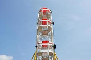 carnaval, ferris wiel over- blauw lucht in amusement park in zomer foto