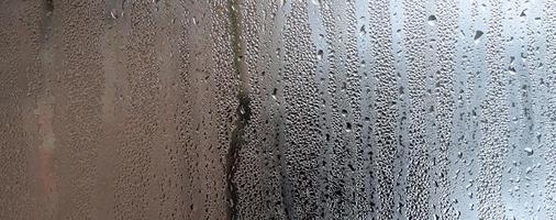 structuur van een laten vallen van regen Aan een glas nat transparant achtergrond. afgezwakt in grijs kleur foto