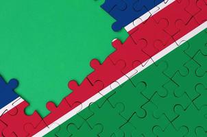 Namibië vlag is afgebeeld Aan een voltooid decoupeerzaag puzzel met vrij groen kopiëren ruimte Aan de links kant foto