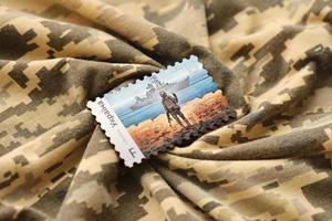 ternopil, Oekraïne - september 2, 2022 beroemd oekraïens poststempel met Russisch oorlogsschip en oekraïens soldaat net zo houten souvenir Aan leger camouflage uniform foto